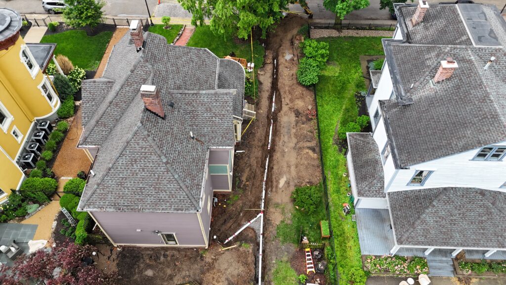 Aerial view of a sewer line replacement trench between two Indianapolis homes