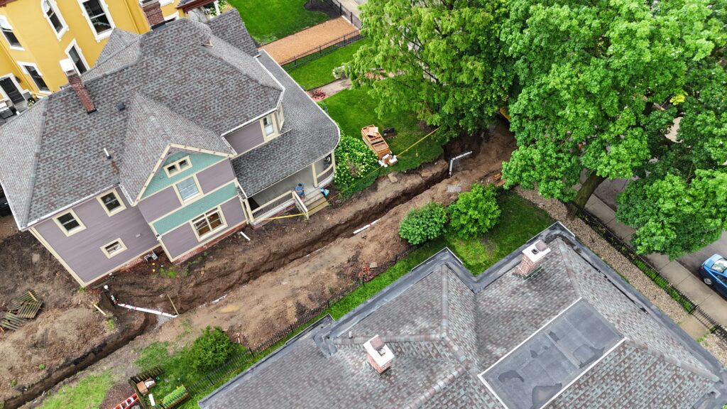 Drone view of a backyard sewer line trench during a full replacement in Indianapolis