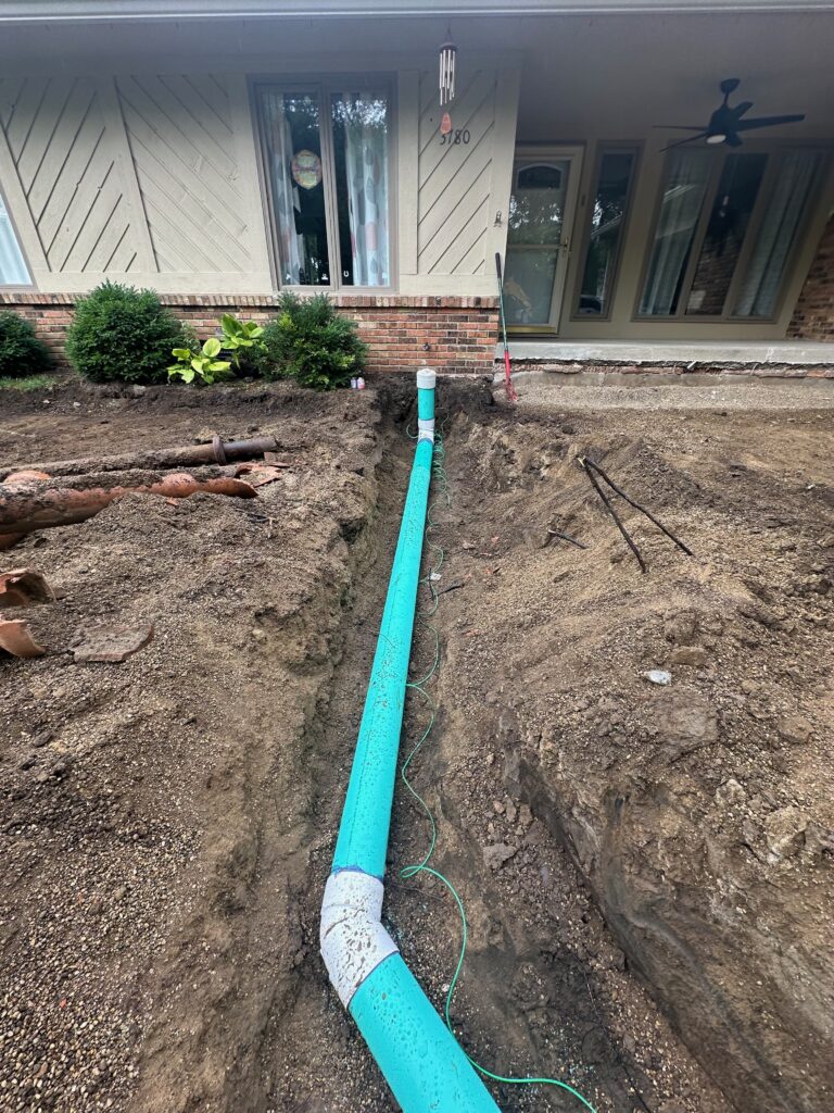 New PVC sewer line laid in a front-yard trench during a full sewer replacement in Indianapolis